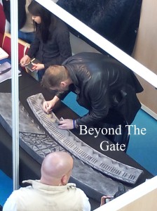 Michael Shanks dédicace la réplique d'un morceau de Porte des Étoiles. Photo : © Beyond The Gate